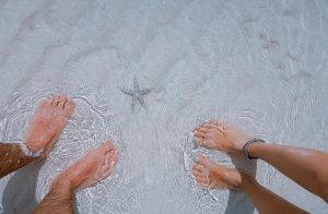 Feet in beach with starfish